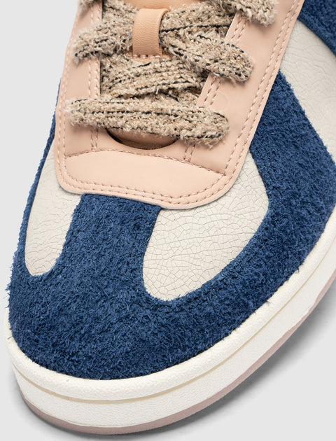 Close-up of men's blue and beige textured sneaker with thick laces and suede details