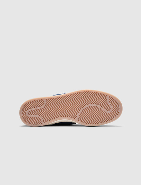 Gum outsole of a low-top sneaker with herringbone tread pattern on white background