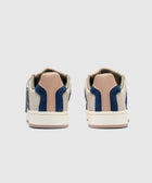 Rear view of beige and navy blue low-top sneakers with tan heel accents on white background