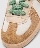 Close-up of brown suede and white leather sneaker with green laces, streetwear style