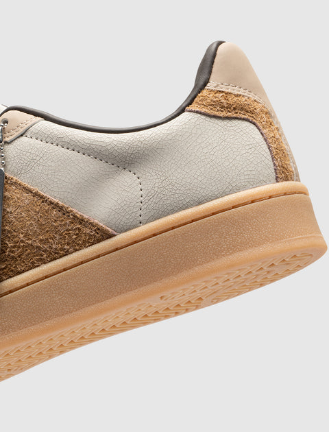 Close-up of men's streetwear sneaker in beige, cream, and brown with textured sole