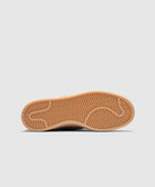 Brown gum rubber sneaker outsole with herringbone traction pattern on white background