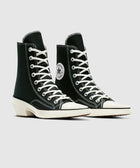 Black and white high-top canvas sneakers with white laces and rubber soles, streetwear style.
