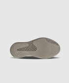 Beige sneaker sole with textured, ventilated pattern on light background