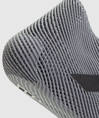 Close-up of grey sneaker sole with breathable mesh texture and modern design details.