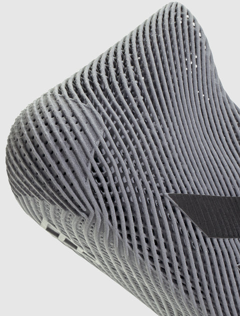 Close-up of grey sneaker sole with breathable mesh texture and modern design details.