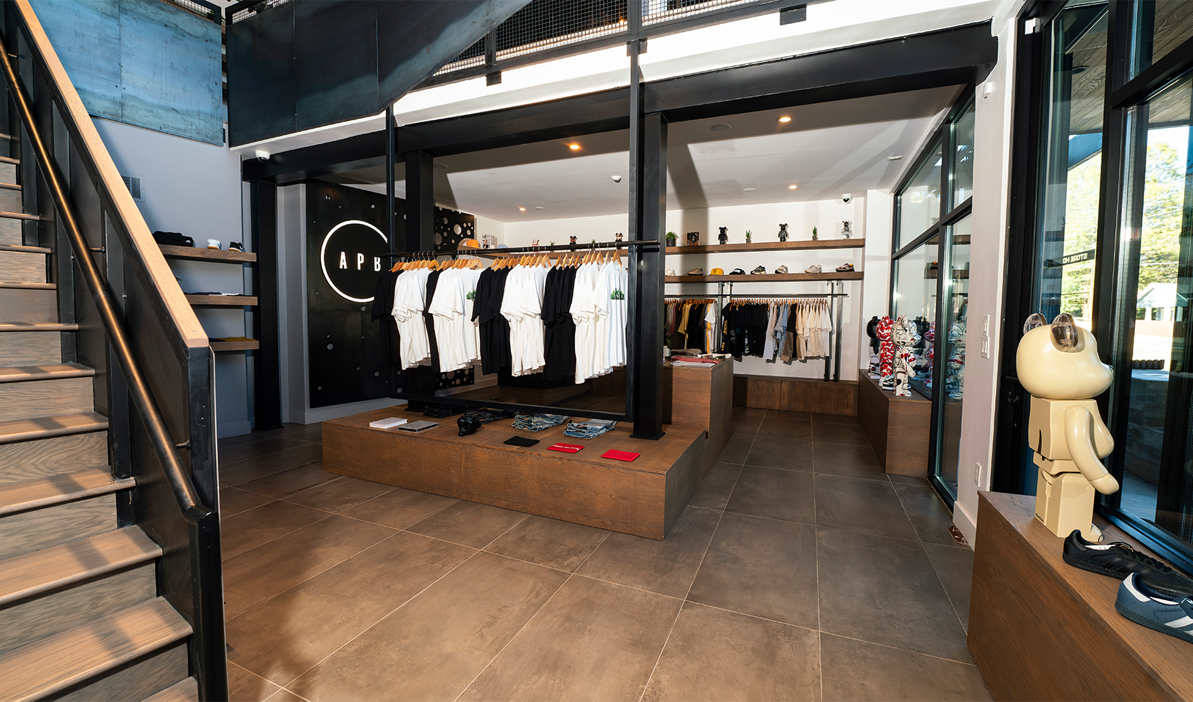 Modern streetwear clothing store interior with trendy men's tops, sneakers, and accessories on display