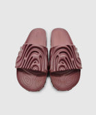 Pair of textured maroon slide sandals with sculpted top strap on plain background