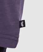 Close-up of purple t-shirt hem with black Nike SB tag, streetwear apparel detail
