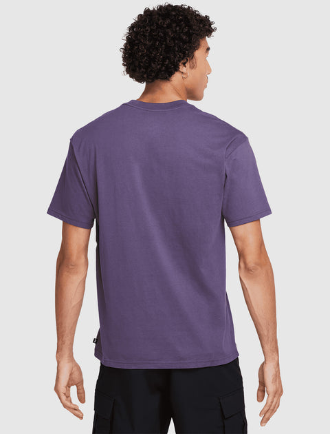 Back view of man wearing a purple short sleeve streetwear t-shirt and black cargo pants