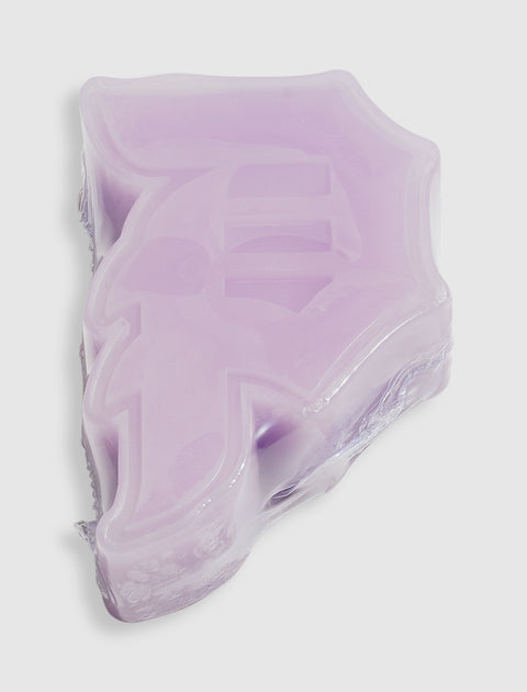 Lilac purple soap bar shaped like a stylized graphic emblem, isolated on white background