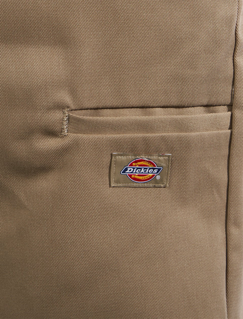 Close-up of khaki pants with a pocket and visible Dickies logo patch, streetwear style.