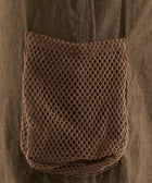 Close-up of brown mesh pocket on khaki streetwear apparel