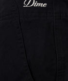 Close-up of black pants pocket with white Dime logo embroidery, men's streetwear fashion.