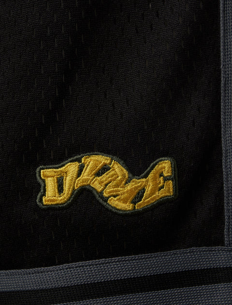 Black mesh fabric with yellow embroidered patch and grey trim, streetwear detail