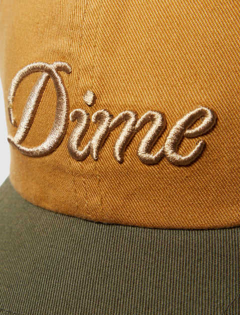 Closeup of brown and green cap with gold embroidered "Dime" logo, streetwear accessory