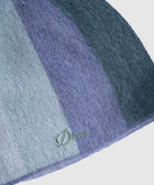 Close-up of a fuzzy blue and purple knit beanie with embroidered Dime logo