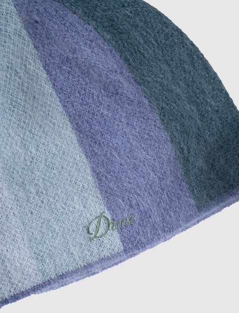 Close-up of a fuzzy blue and purple knit beanie with embroidered Dime logo