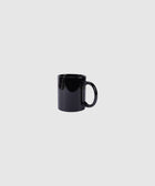 Glossy black ceramic coffee mug on plain light gray background