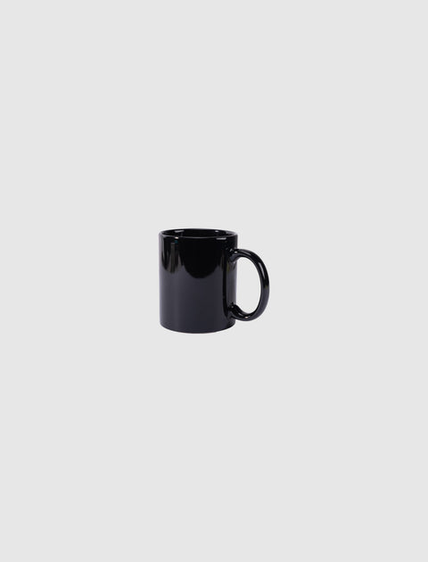 Glossy black ceramic coffee mug on plain light gray background
