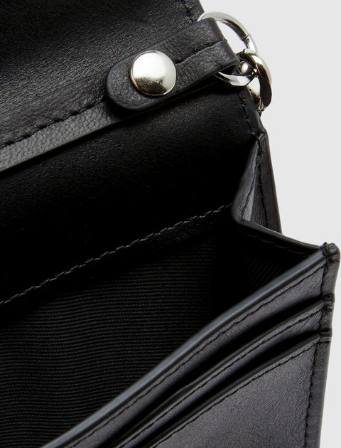 Close-up of black leather wallet with silver snap and stitched details