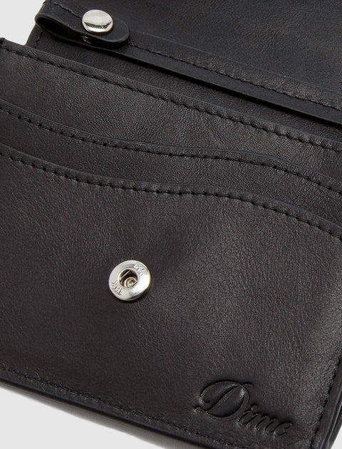 Closeup of a black leather wallet with embossed Dime logo and metal snap closure.