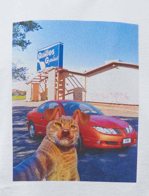 Graphic print t-shirt featuring a surreal cat-dog hybrid, red car, and bowling alley