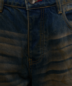 Close-up of blue denim jeans with yellow stitching and wavy faded pattern