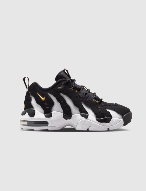 Black and white men's sneaker with gold accents, chunky sole, side view on plain background