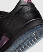 Close-up of black leather sneaker with pink stitching and translucent sole