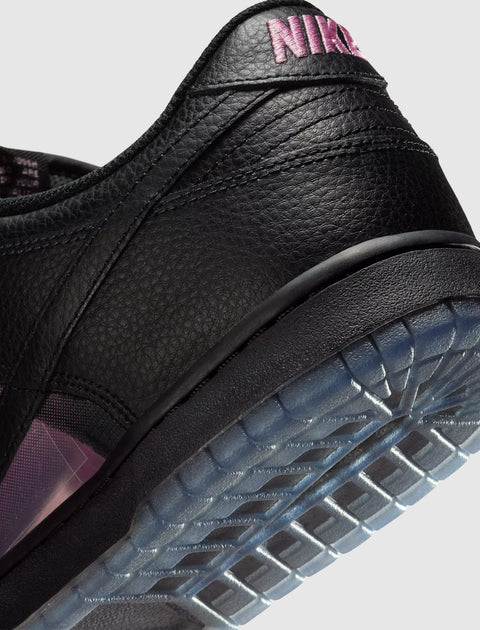 Close-up of black leather sneaker with pink stitching and translucent sole