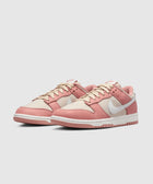 Low-top sneakers in pink and beige with a white swoosh logo, side view on white background