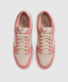 Top view of beige and pink Nike low-top sneakers with white soles on a plain background.