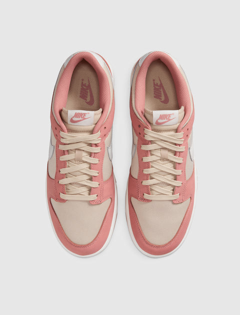 Top view of beige and pink Nike low-top sneakers with white soles on a plain background.