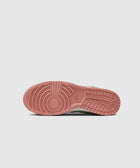 Red rubber outsole of a Nike sneaker with circular tread and branding, streetwear shoe