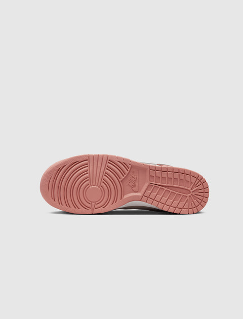 Red rubber outsole of a Nike sneaker with circular tread and branding, streetwear shoe