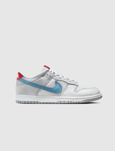 Low-top sneaker in silver with blue swoosh, red heel tab, and white sole on a plain background.
