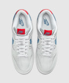 White and blue low-top sneakers with red tongue tags and Nike branding, top view