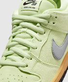 Close-up of Nike SB Dunk Low Pro sneaker in light green suede with gray Swoosh and gum sole