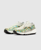 Men's woven low-top sneakers with multicolor accents and white midsoles on gray background