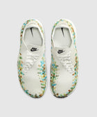 White woven sneakers with multicolor accents, top view, featuring Nike logo and laces.