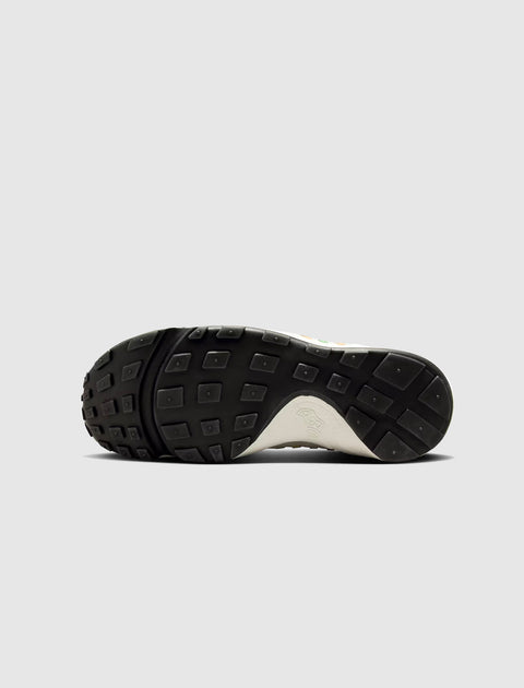 Closeup of sneaker outsole with black rubber tread and textured grip pattern on a white background.