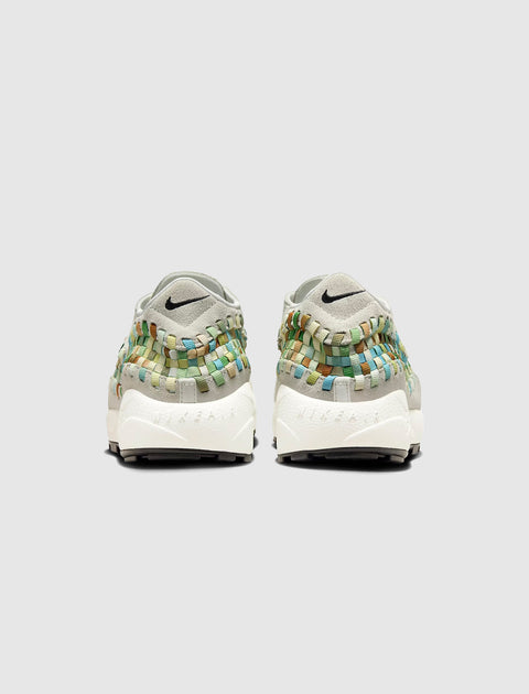 Rear view of woven multicolor sneakers with white soles and light grey heel, studio background