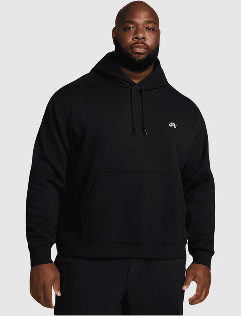 Man wearing a black Nike SB hoodie with front pocket and drawstrings, streetwear style