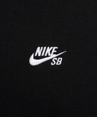 Close-up of black fabric with white Nike SB logo embroidery, streetwear apparel detail