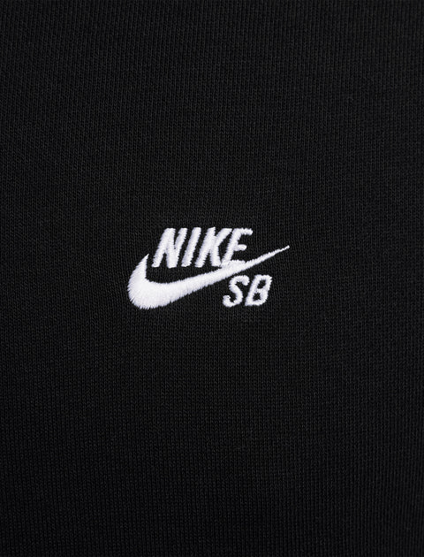 Close-up of black fabric with white Nike SB logo embroidery, streetwear apparel detail
