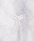Close-up of white embroidered logo on textured white fabric, streetwear apparel detail