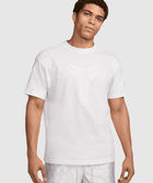 Man wearing a white graphic streetwear t-shirt and light patterned shorts