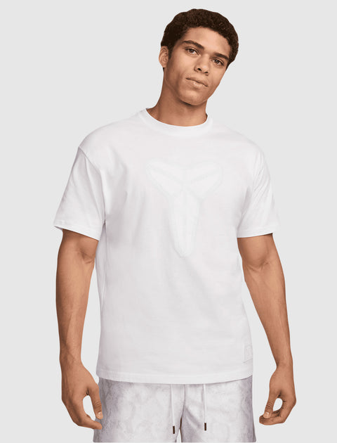 Man wearing a white graphic streetwear t-shirt and light patterned shorts