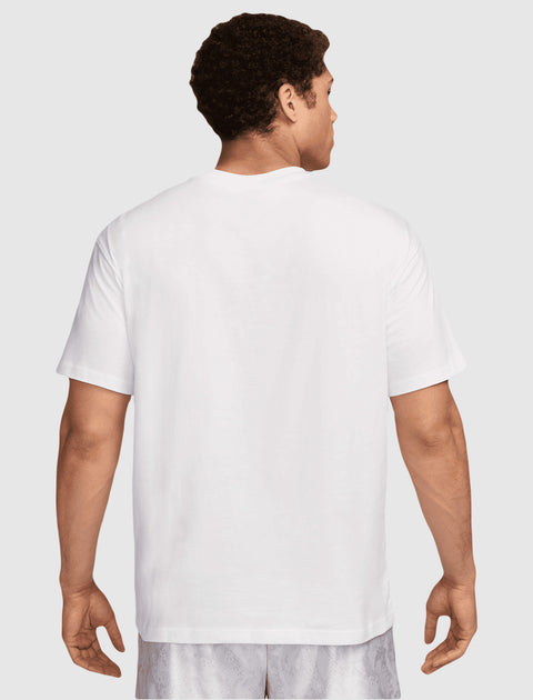 Man wearing plain white short sleeve t-shirt and light patterned shorts, back view